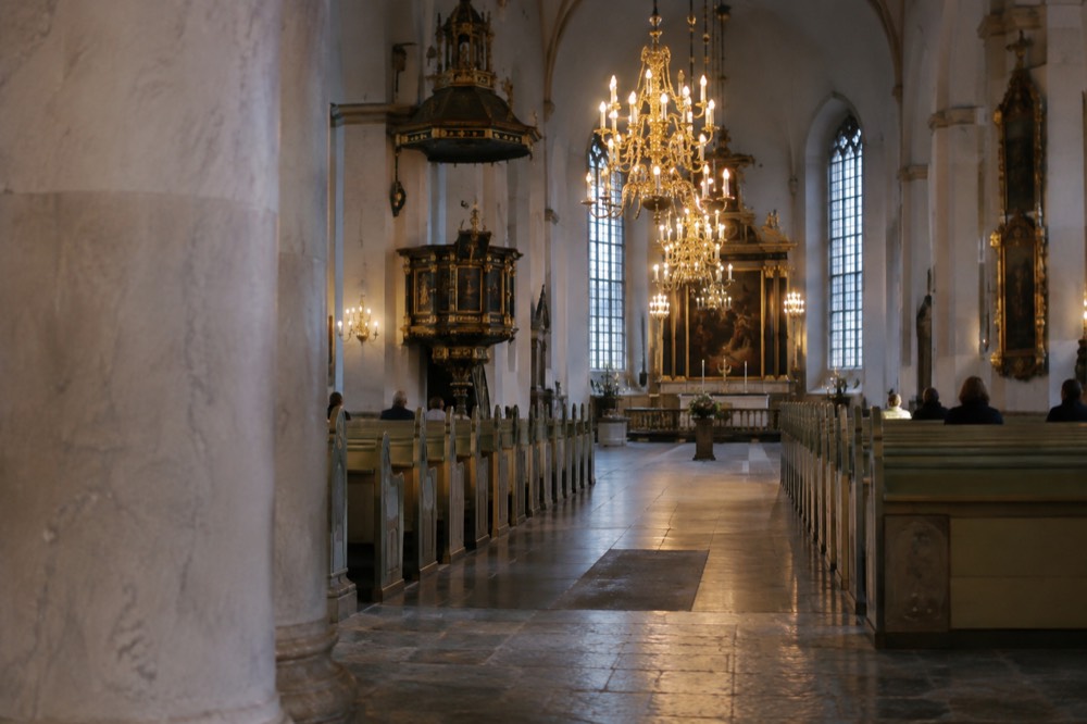 Interior of Oslo Cathedral with pale walls, columns and tall windows