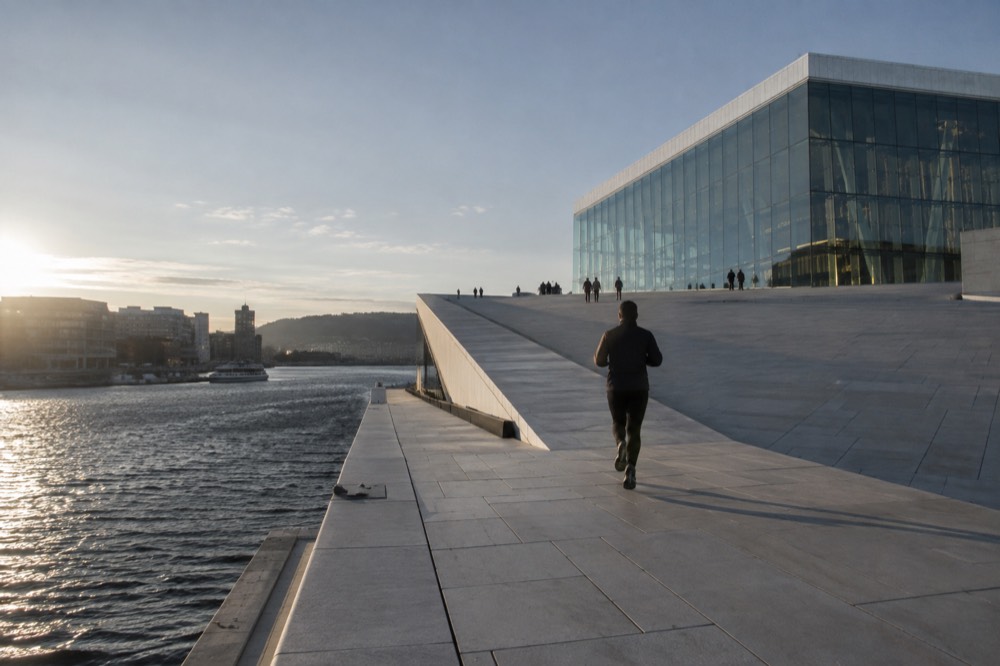 Sloping white marble roof of the Oslo Opera House seen from the waterfront promenade