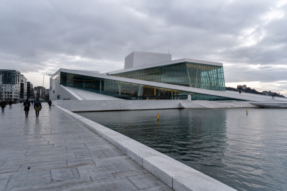 Waterfront promenade leading toward the Opera House with the harbor on one side