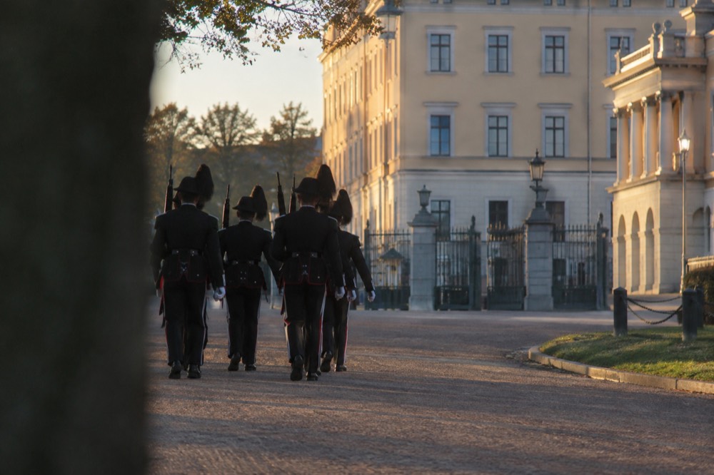 Royal guard soldiers marching toward the palace gates in Oslo