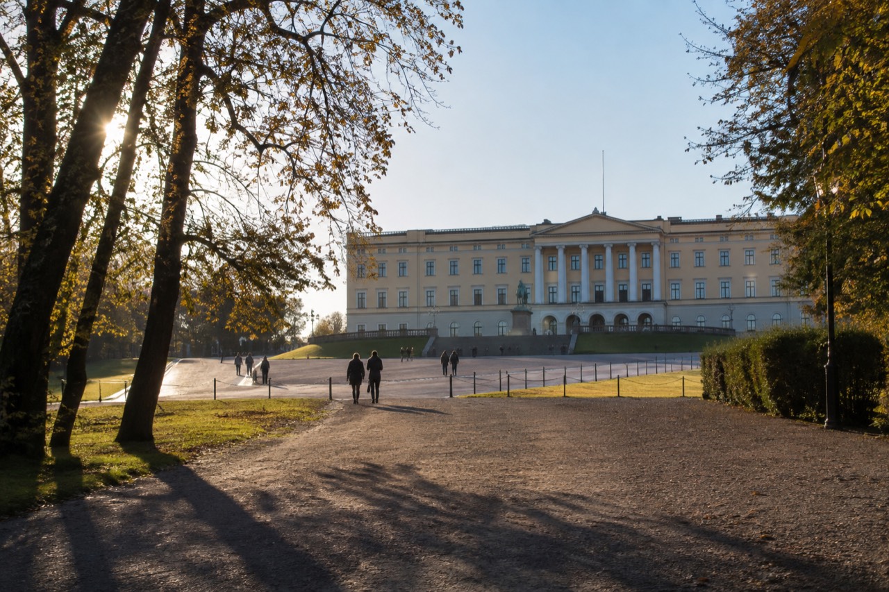 The yellow front facade of the Royal Palace in Oslo seen from the Palace Square at the top of Karl Johans gate