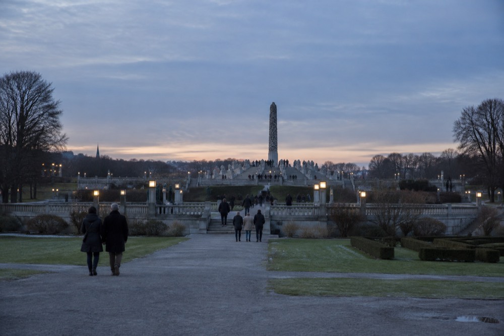 A long granite staircase rising toward a tall carved column in a park