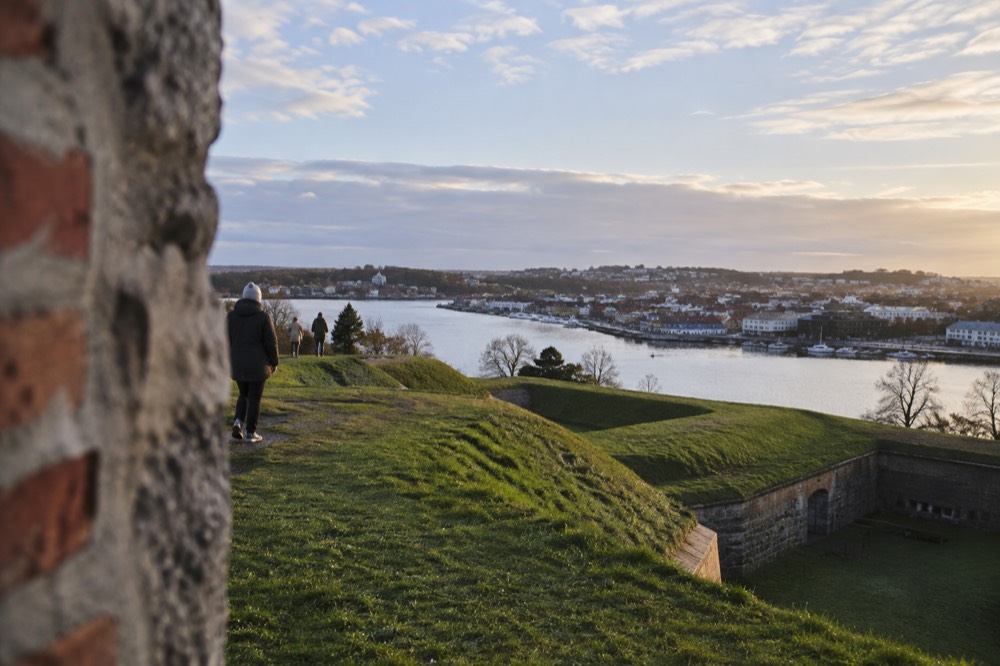 Grass-covered bastion earthworks with a wide view over a river town