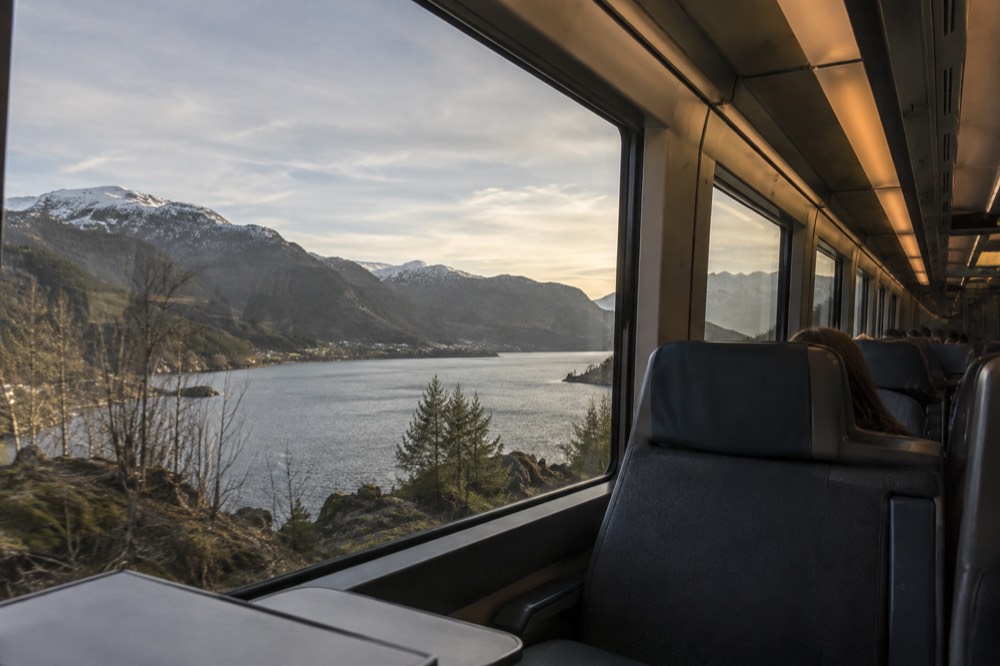 The interior of a modern Norwegian train with large windows and reclining seats