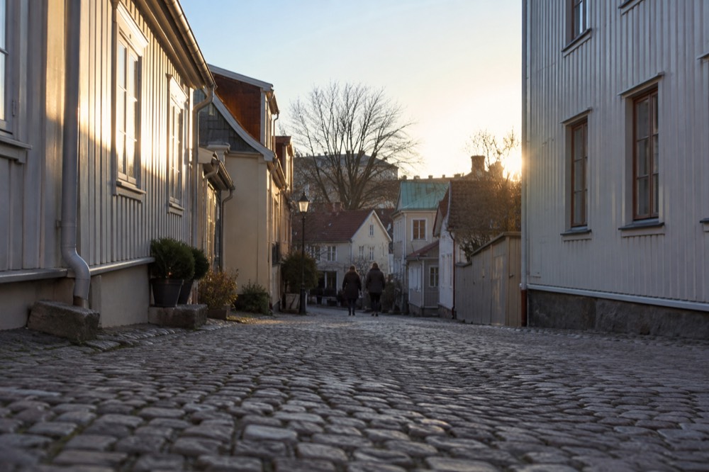 Cobbled street lined with low wooden houses in an old city district