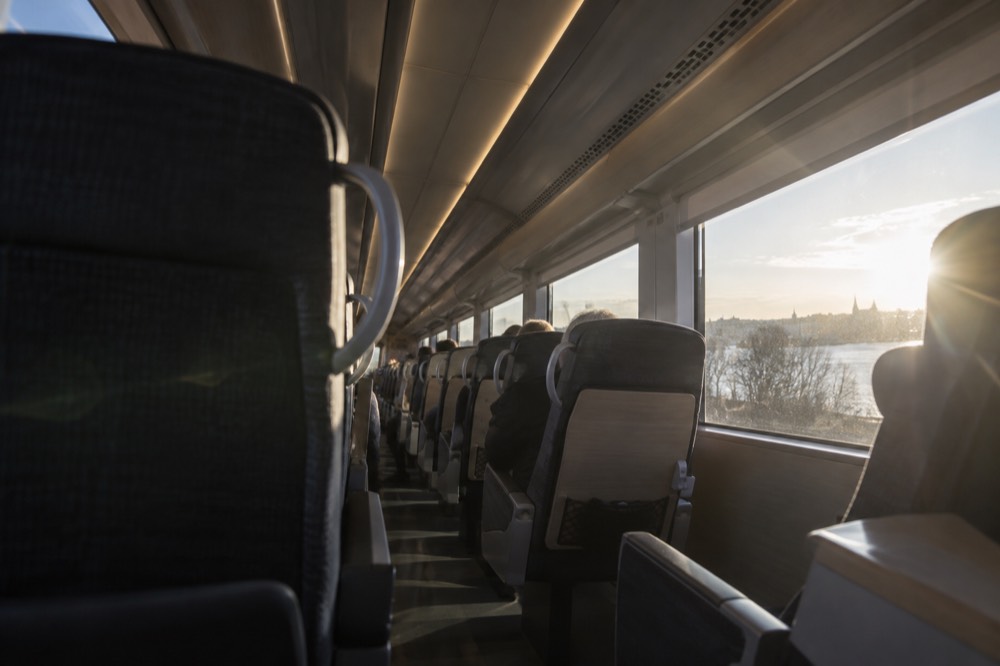 Interior of a modern intercity train with rows of seats and large windows