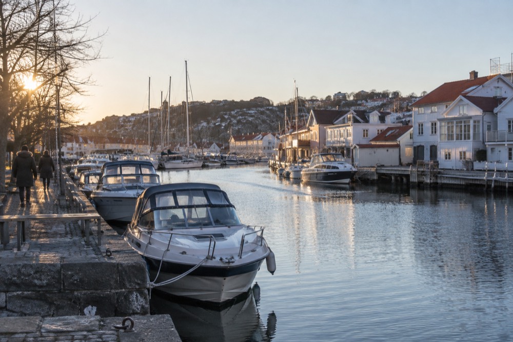 Canal in a Swedish city lined with low buildings and moored boats