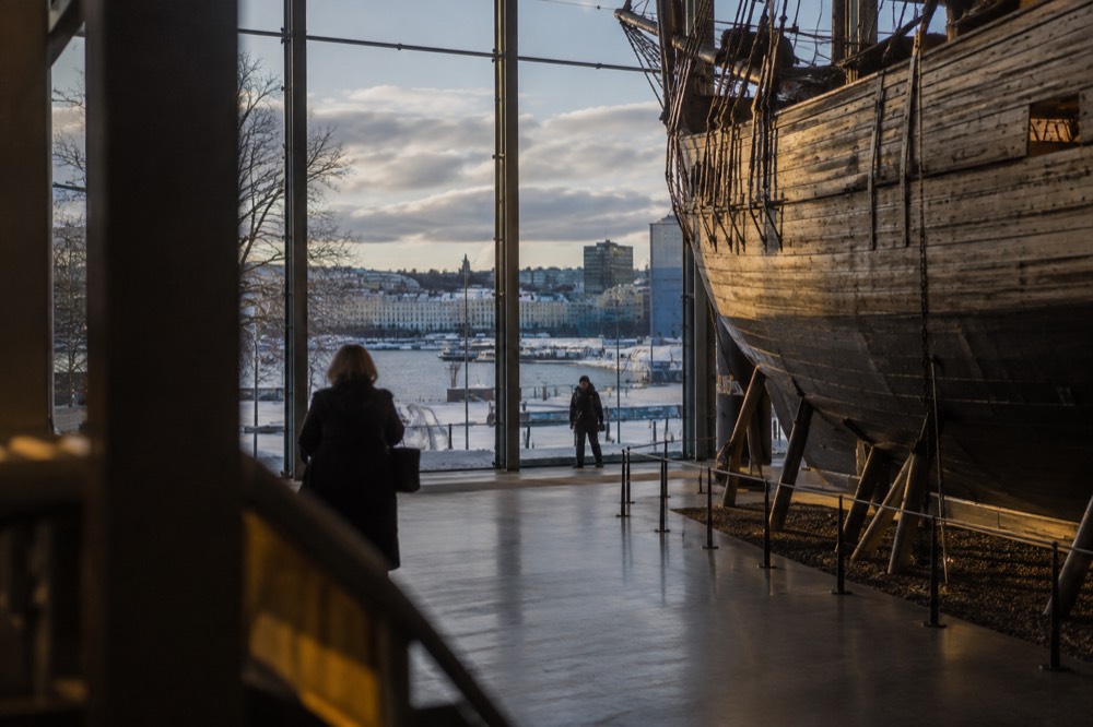 Interior of a polar museum with a wooden expedition ship hull lit warmly