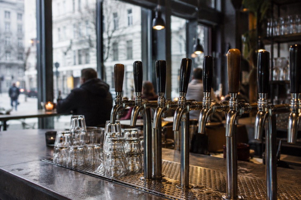 Rows of beer taps on the counter of a small Oslo craft bar