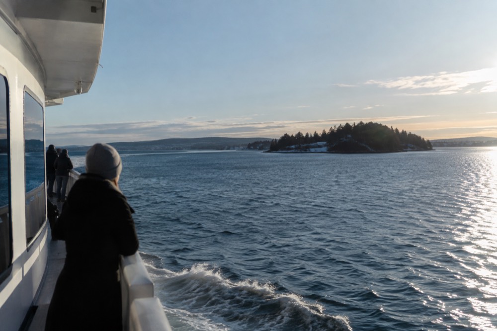 Passenger ferry crossing open water toward a small green Oslofjord island