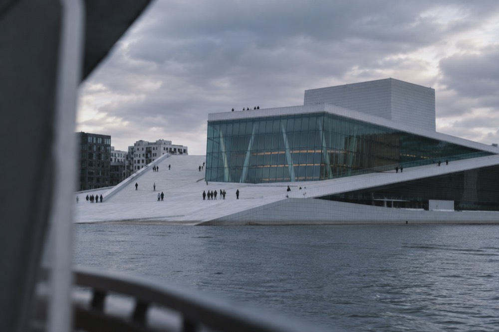 The sloping marble roof of the Oslo Opera House seen from the water