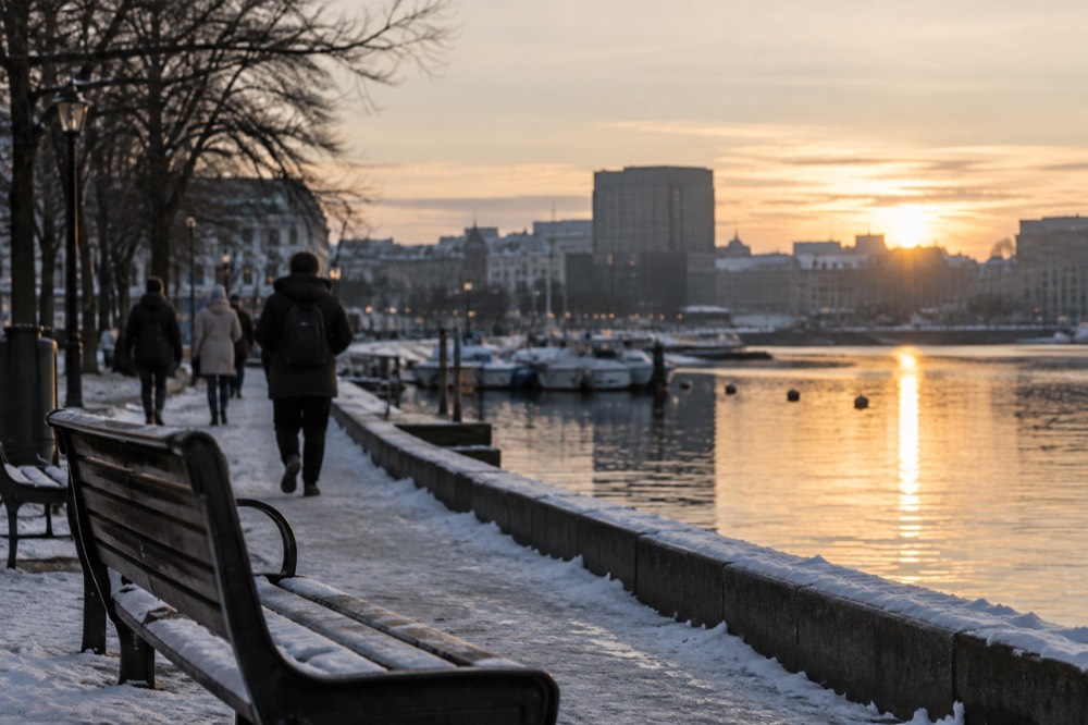 City lights reflecting in fjord water on a winter evening