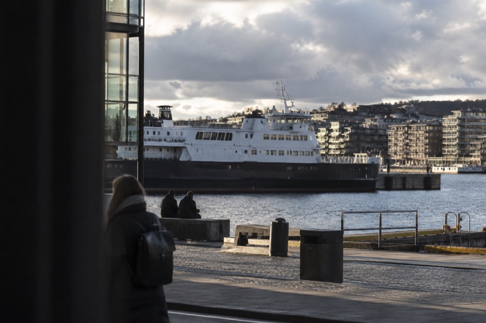 Ferry ship moored at a city quay with residential buildings behind it