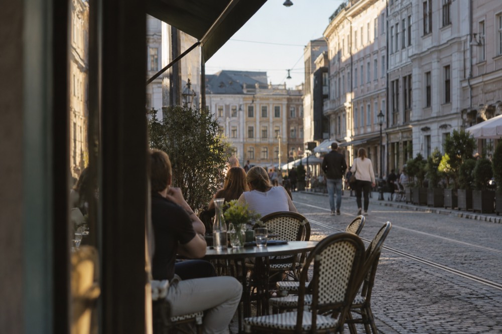 Outdoor café tables along a cobblestone street in central Oslo