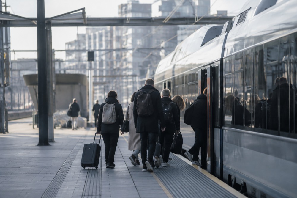 Modern train platform at Oslo Central Station with travelers boarding