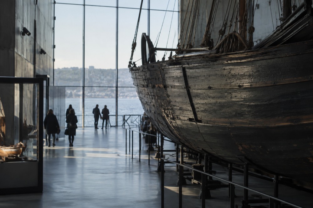 Museum interior with a large wooden expedition ship hull displayed