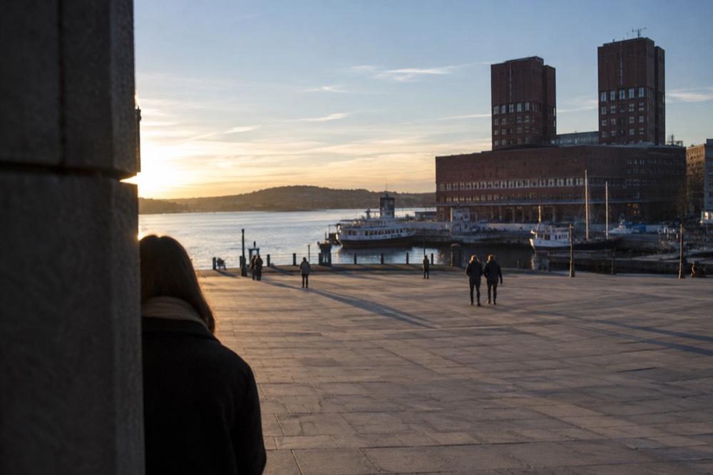 Oslo city hall and the fjord piers seen across the water on a bright morning