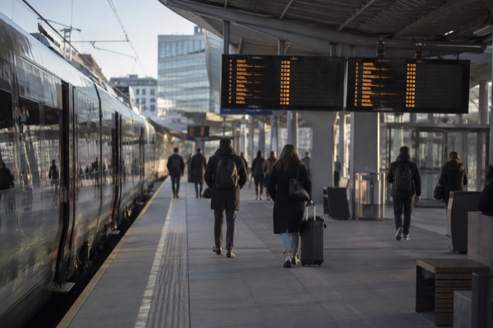 A modern train platform at Oslo central station with a departures board