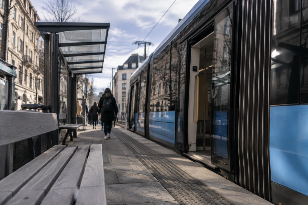 Modern low-floor tram at a central Oslo stop with level boarding platform