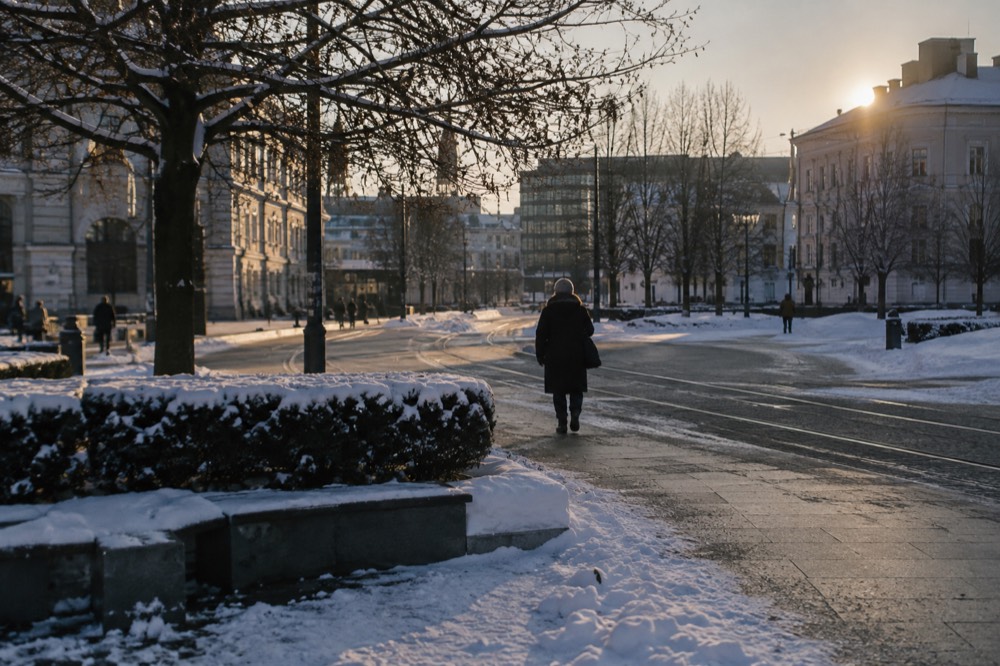Snow-dusted flat city square in central Oslo with cleared walkways