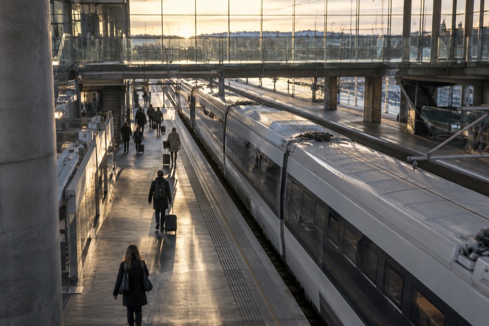 Airport express train platform with a sleek white train waiting at an indoor station