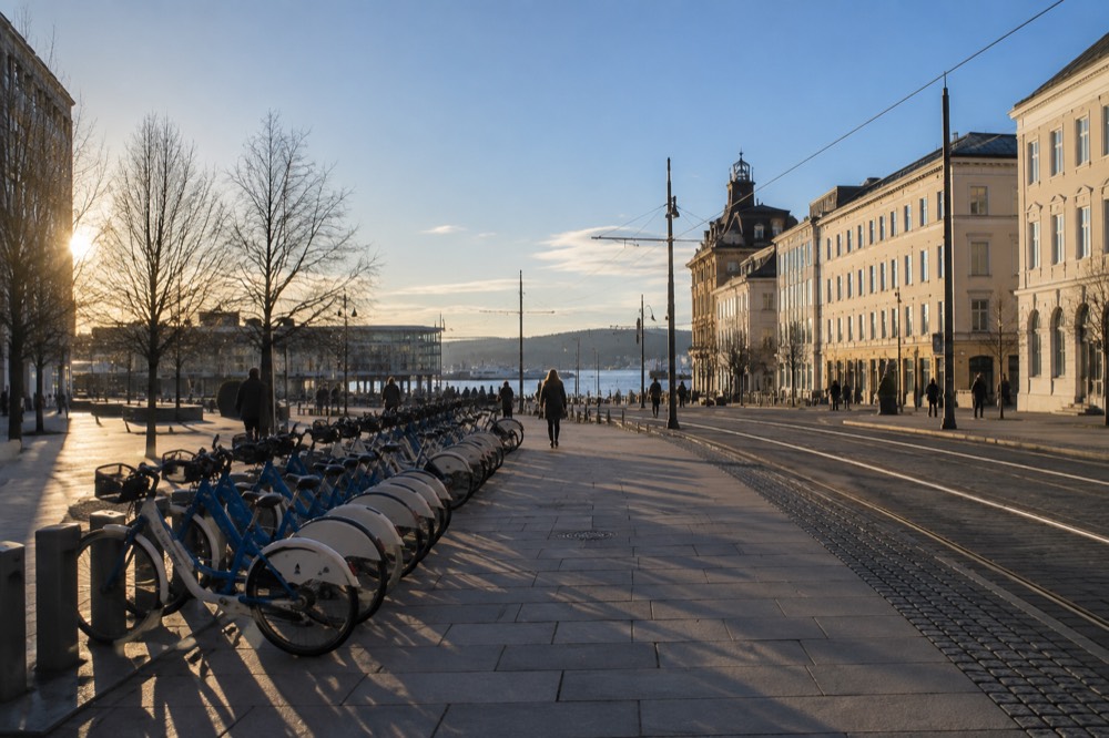 A row of shared city bicycles locked in docking stations beside a city square