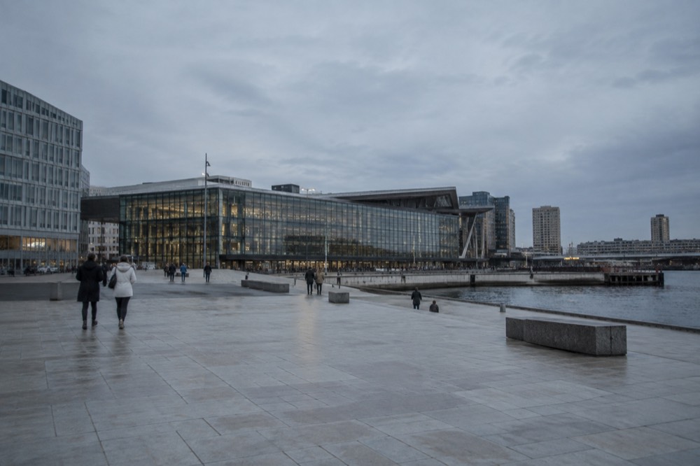 The glass facade of Oslo Central Station seen from the plaza in front of the Opera House