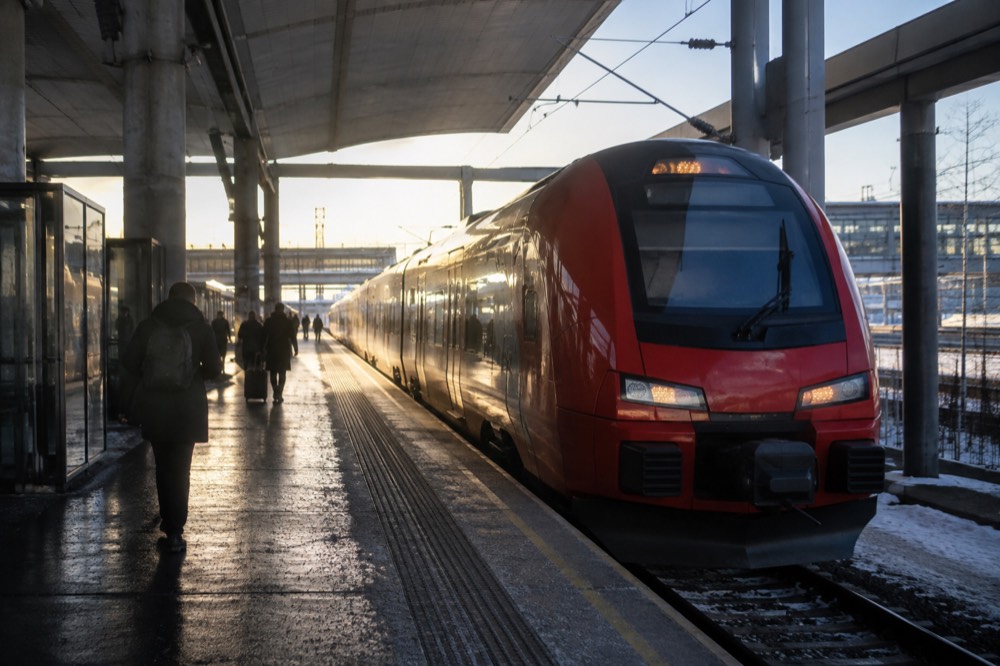 A red airport express train at a platform inside Oslo Central Station