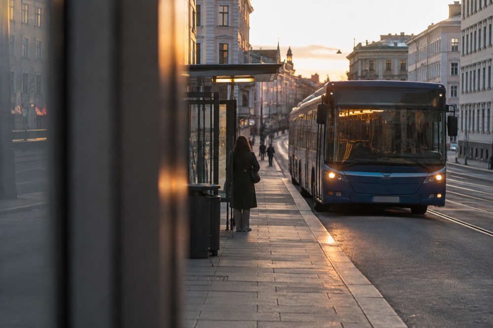 Night bus waiting at an illuminated stop on an empty city street