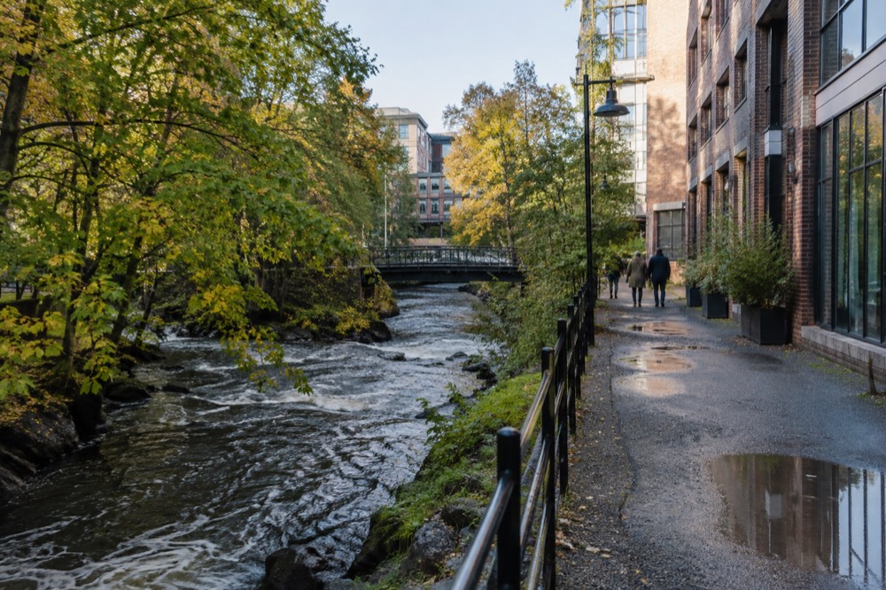 The Akerselva river path with trees and industrial brick buildings in Oslo