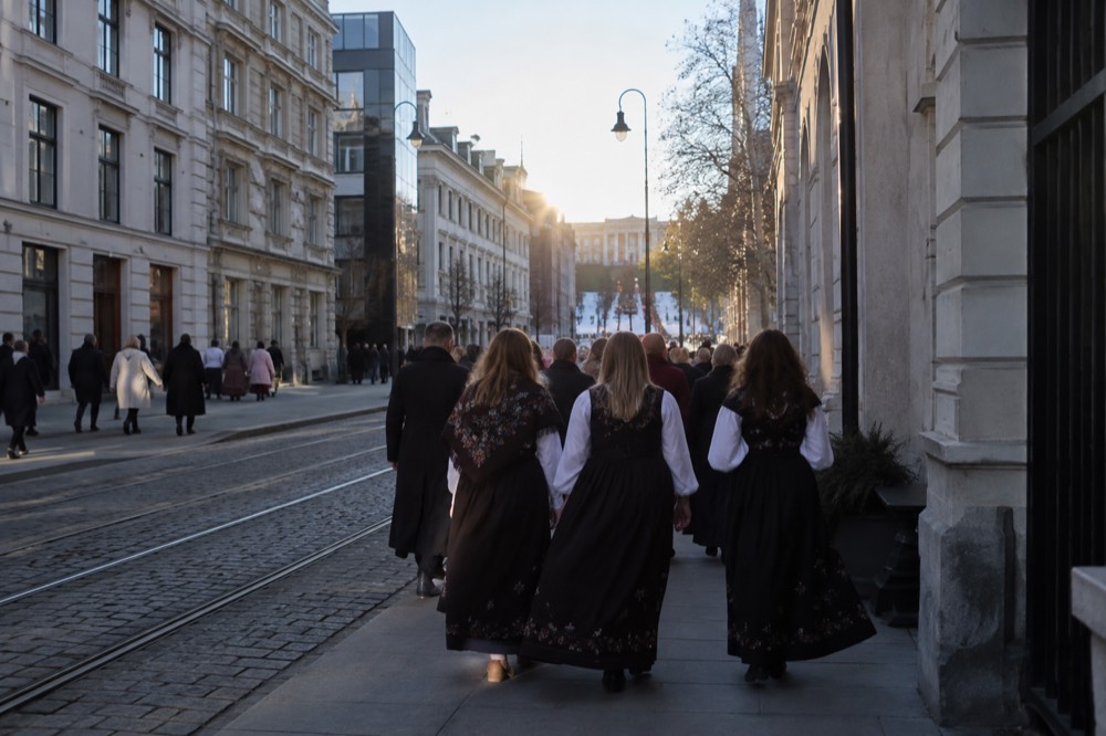 People in traditional Norwegian dress walking along a flag-decorated street in central Oslo