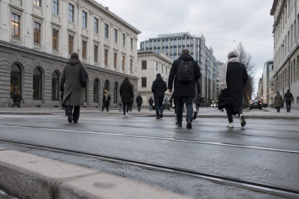 Pedestrians crossing a central Oslo street in front of historic facades