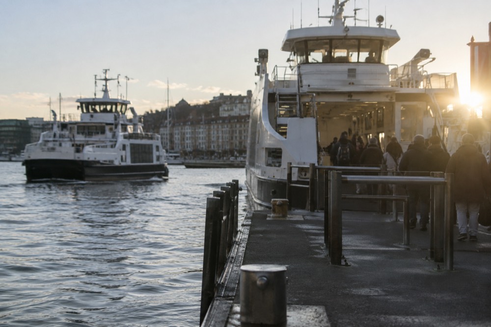 Two ferries at adjacent piers with passengers boarding at one of them