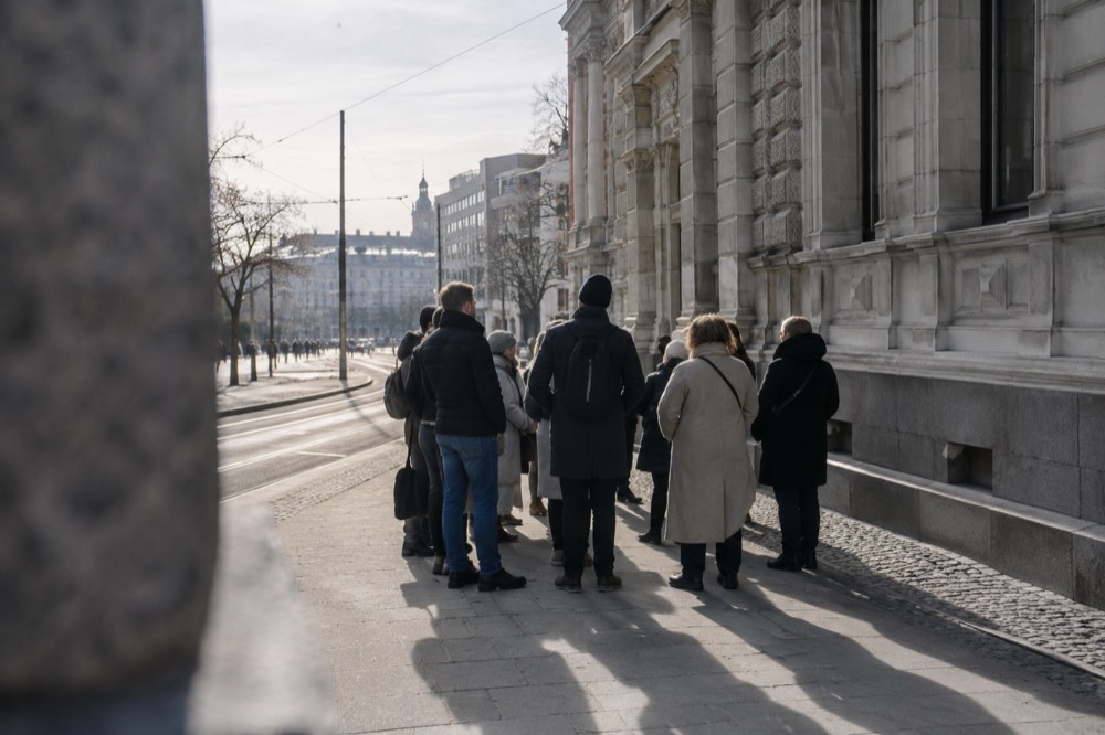 Walking tour group gathered beside historic buildings on a city street in Oslo