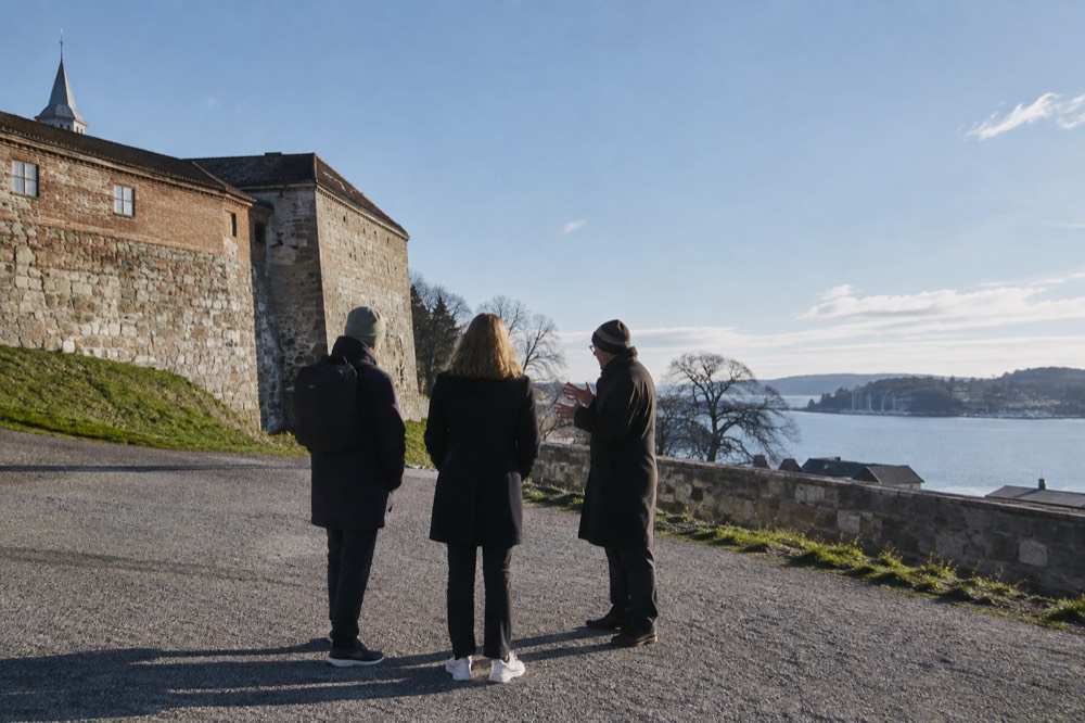 Private guide talking with a couple outside Akershus Fortress in Oslo