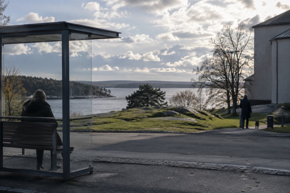 A bus stop near a museum building on a green peninsula in Oslo