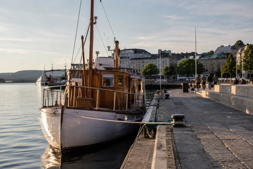 Wooden ferry boat moored at a city pier on calm water