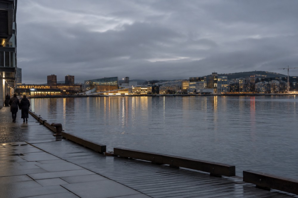 Evening lights reflecting on the Oslofjord waterfront with the city skyline behind