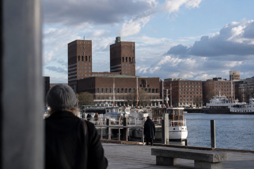 Oslo city hall waterfront with ferry pier and fjord boats in daylight