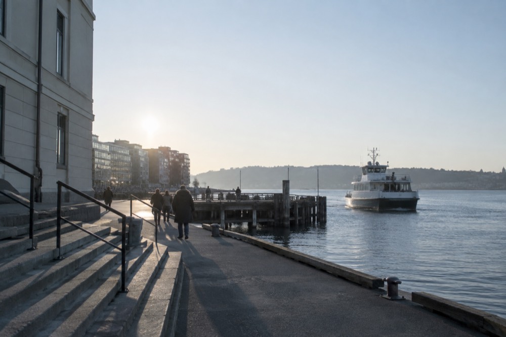White passenger ferry approaching a wooden pier on the Oslofjord