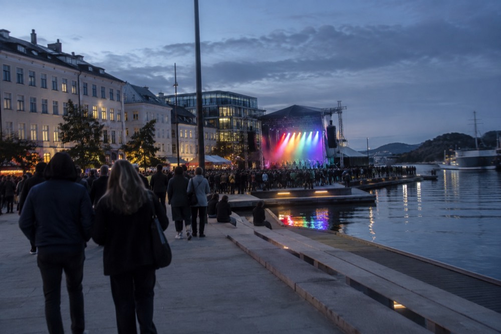 A stage with rainbow lighting set up in a waterfront square