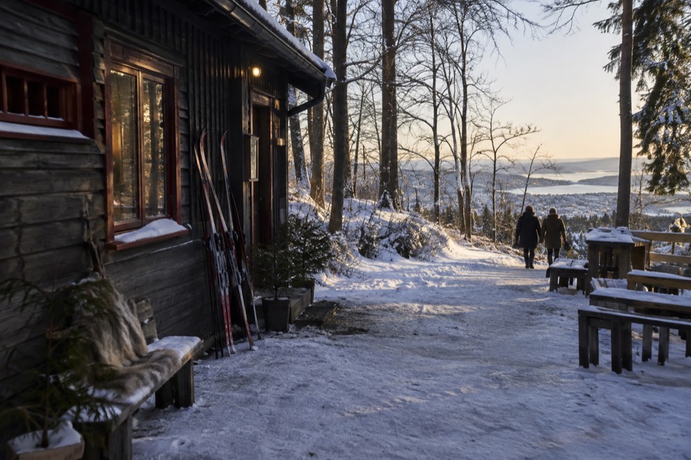 Wooden cabin cafe with skis leaning against the wall in snowy forest