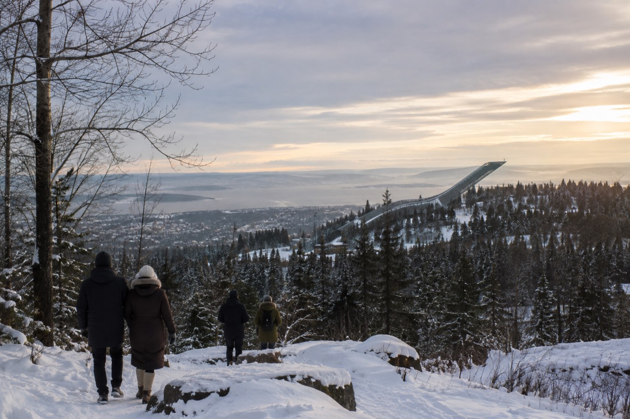 Snow covered ski jump tower above forested hills at the edge of Oslo