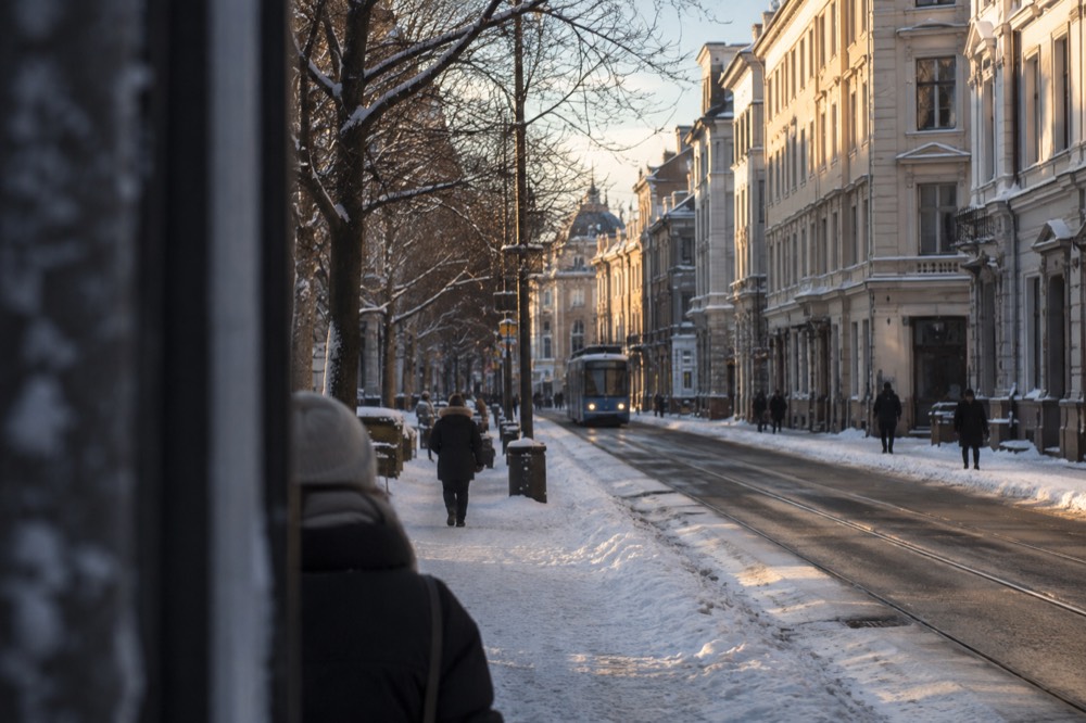 Snow-covered street in central Oslo with warm light on building facades