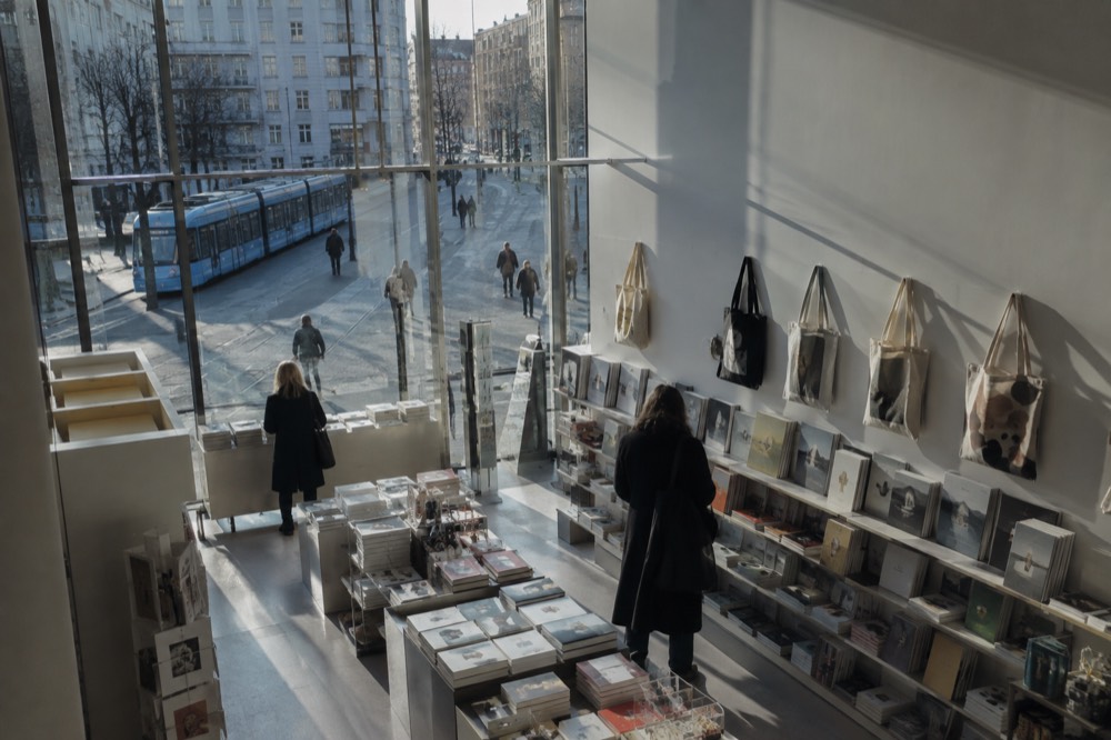 Shelves of art books and printed tote bags in a museum gift shop