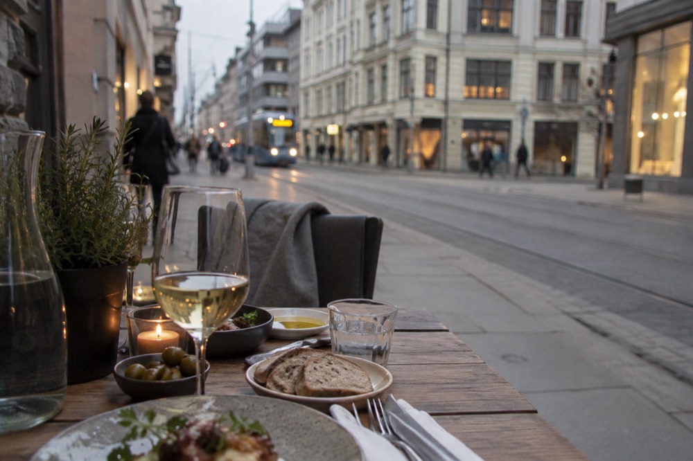 Small plates and glasses on a wooden restaurant table in evening light