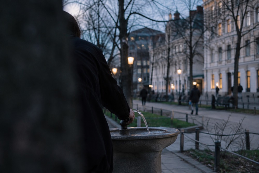 Clear water pouring from a public drinking fountain in an Oslo park