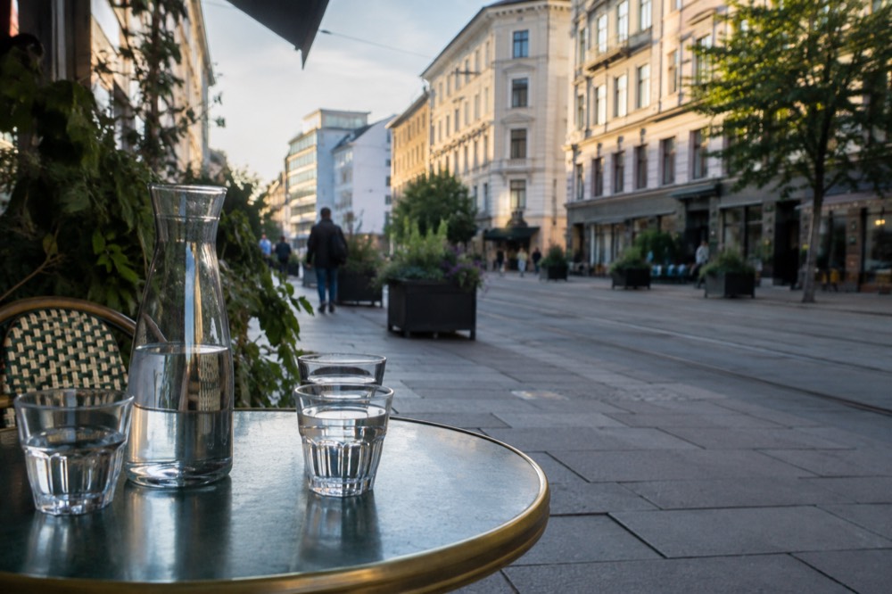 A carafe of water and two glasses on a cafe table in Oslo