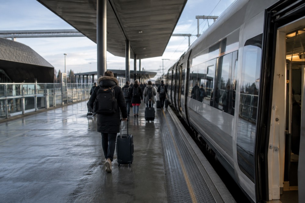Modern train platform at Oslo Airport Gardermoen with passengers boarding