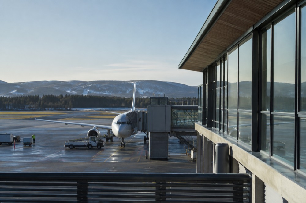 Small regional airport terminal building beside a runway in Norway